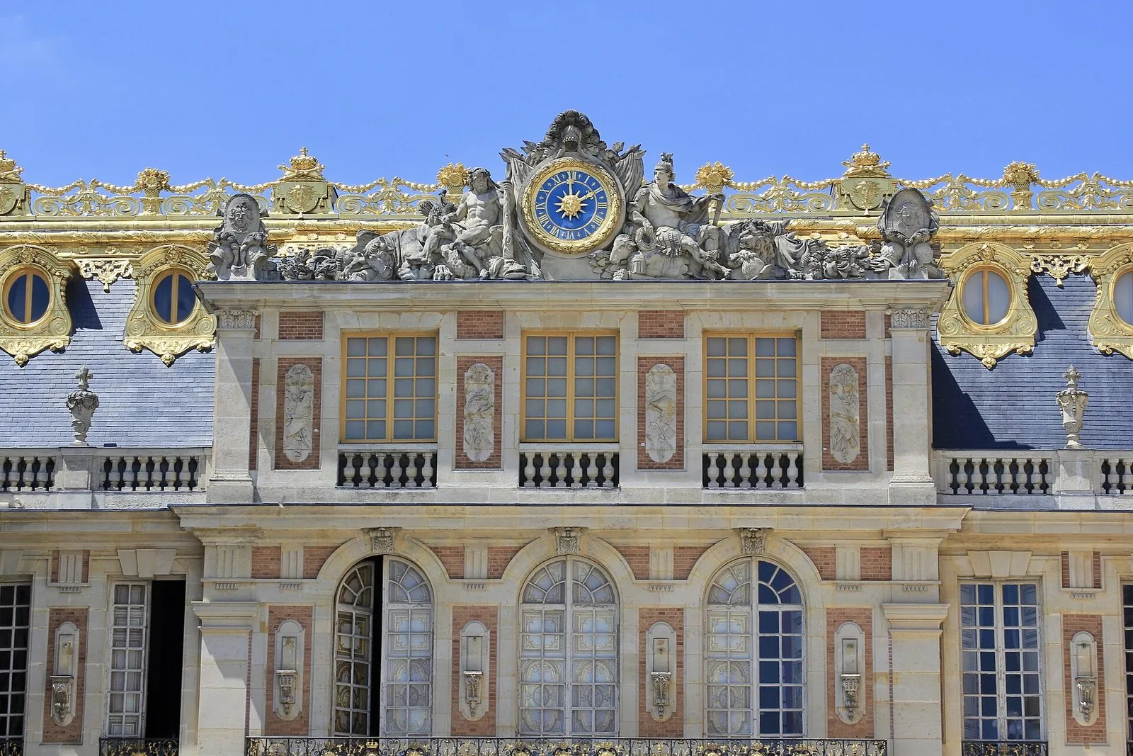 Facciata del Château de Versailles sulla Cour de marbre, con l'orologio, le sculture e le decorazioni dorate del tetto